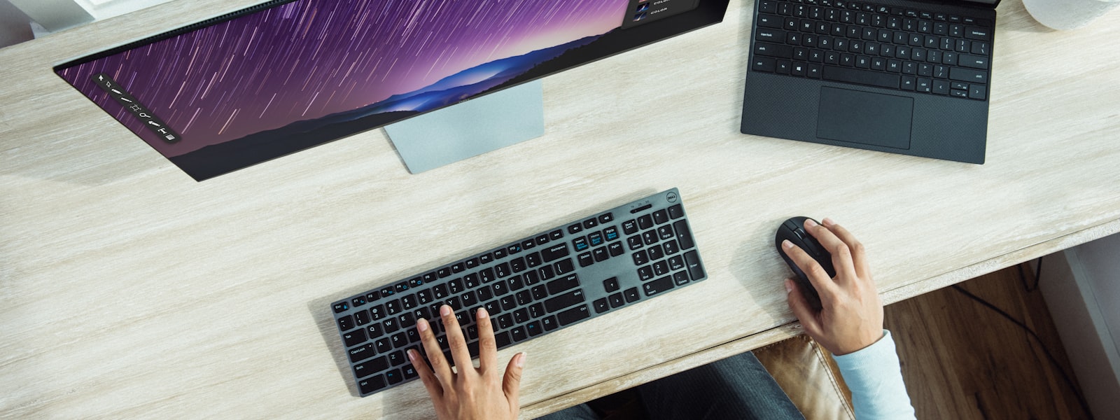 USB-C hub connected to a laptop with cables routed across a dark walnut desk in a modern home office